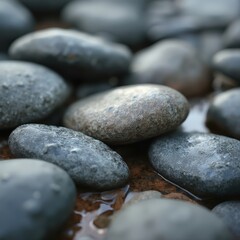 A close-up background of smooth, rounded river stones in shades of gray and earthy brown