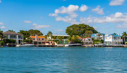 Obraz premium Vacation in summer. Luxury waterfront hotel building. Summer vacation. Yacht in luxury residential. Residential waterfront apartment with boat. Waterfront landscape with house. Travel destination