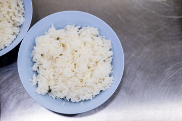 Tasty hot rice on blue dish on a stainless steel table