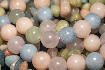 Macro photo showcasing the vibrant colors and textures of natural beryl stone beads. Ideal for beaded jewelry crafters. Morganite, aquamarine and green beryl stone beads for bracelets and necklaces.