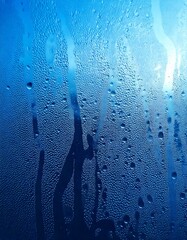 Blue pure water drops, isolated, blue background, realistic rain droplets, dew on glass, smooth reflections, glistening surface, fresh ambiance, soft gradients, transparent clarity.

