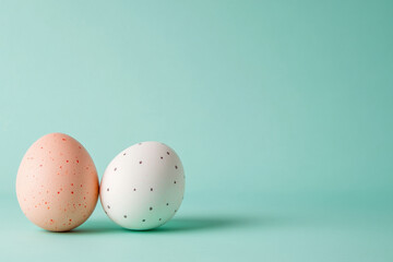 Pastel colored speckled eggs on a soft mint green background with smooth shadows