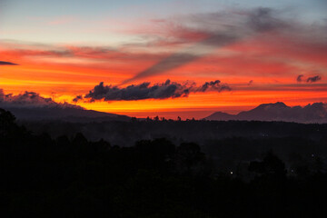 Naklejka premium Sunset and black shadows in Bukittinggi with a backdrop of the Bukit Barisan hills of Sumatra and tropical forests in West Sumatra, Indonesia on July 13, 2018