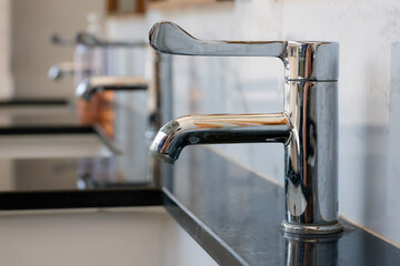 sleek chrome faucet installed on a polished black marble counter