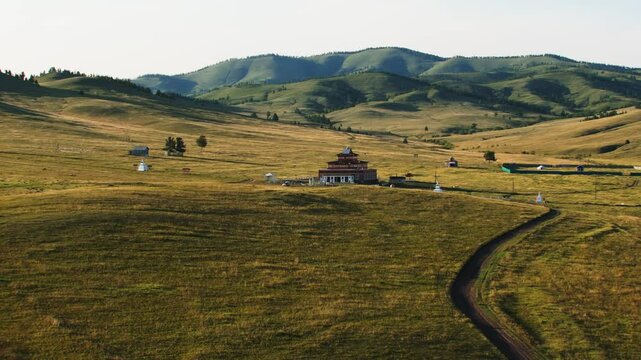 A peaceful Buddhist temple (datsan) standing amidst vast fields, blending spiritual serenity with the natural beauty of the surrounding landscape
