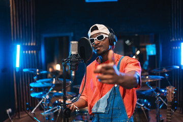 Young stylish singer recording new hit song in professional studio