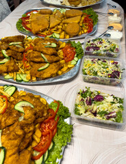 Meat serving bowls for entertaining at a celebration. For the guests, delicacies such as fried steaks, fried cheese, vegetable salads and various others are prepared.