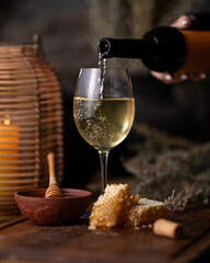 Honey white wine in glass. Pours wine from bottle into glass in restaurant. Wineglass. Evening...