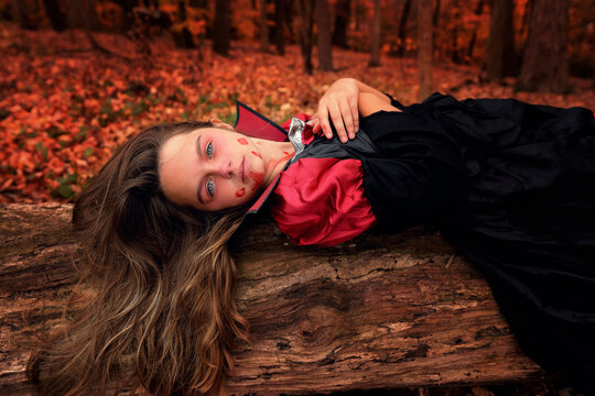 Beautiful tween girl in Vampire costume colorful forest