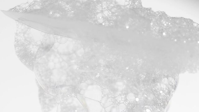 White foam from soap on a spatula close-up. Hygienic product with bubbles for skin cleansing.