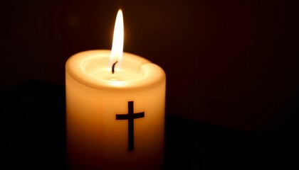 Flickering candle with cross in dim light, moment of reflection