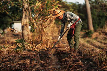 Naklejka premium Farmers use a hoe to dig a ditch for farming.