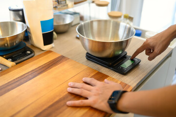 Man measuring ingredients while preparing homemade cookies on countertop