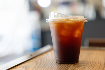 A cup of the ice americano coffee on wooden table.