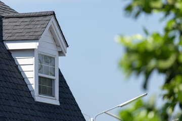 A house with a black roof and a white window