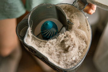 Housekeeper holding a full dust container, emphasizing the significance of regular cleaning and...