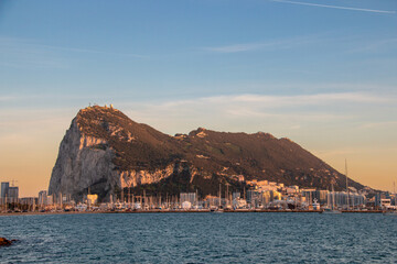 Sunrise over the Rock of Gibraltar with calm waters and coastal skyline in the early morning light
