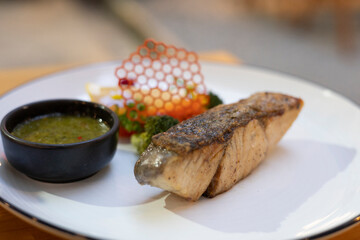 Grilled fish, appetizer salmon, on white plate gourmet cuisine dish, bowl food seafood steak, crispy skin and sauce with green broccoli dipping elegant