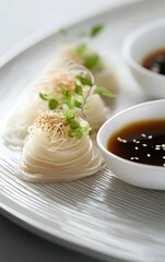 A plate of chilled soba noodles served with a dipping sauce and garnished with finely sliced green onions