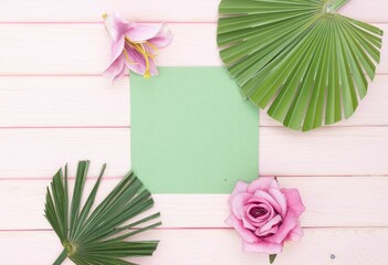 Pink flowers and green leaves on wooden background.