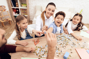 Children put puzzles together with adults.