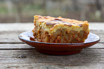  Potato and minced meat  Casserole  with   parmesan cheese and garlic on wooden rustic bakcground.  Bulgarian moussaka