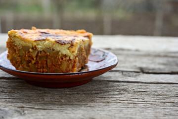  Potato and minced meat  Casserole  with   parmesan cheese and garlic on wooden rustic bakcground.  Bulgarian moussaka