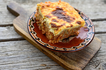 Potato and minced meat  Casserole  with   parmesan cheese and garlic on wooden rustic bakcground.  Bulgarian moussaka