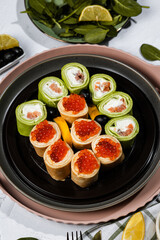 green pancakes rolls with Philadelphia cheese, red fish, red caviar, lemon, olives, pancakes with caviar, spinach, flatlay, Maslenitsa, Japanese rolls, cream cheese with salmon, still life
