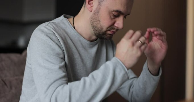 Young man feels concerned due to bad life situation, debt or divorce. Lost in sad thoughts thinking of life or relationships problems.
