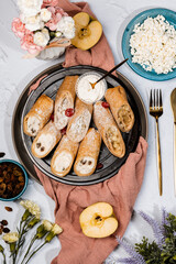 sweet rolls, pancakes with cottage cheese, raisins, apples, powdered sugar and dried cranberries, pancakes with sour cream, flatlay, beautiful light composition with dessert, roses, carnation flowers