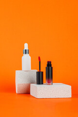 White tube and red spray on light white podiums. White blank unbranded flacons with cosmetology products. Professional concept of skin care on orange background.
