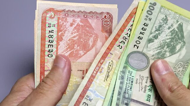 Closeup view of man's hands and wallet with Nepalese rupees banknotes.  Concept of saving money for retirement, cash settlement, financial success, literacy and income planning in Nepal.