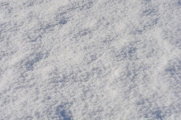 A fresh, powdery snow, with subtle ripples and textures across the white surface