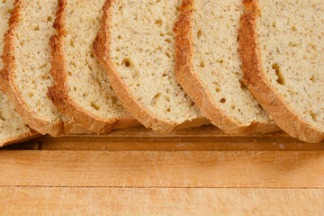 Slices of homemade bread with chia seeds are arranged on a wooden cutting board, showcasing the texture and healthy ingredients