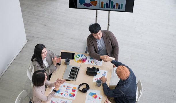 Top view: Happy Asian businessmen and women brainstorming and talking about analysis, innovation, and collaboration. Online business, sales techniques, strategic planning