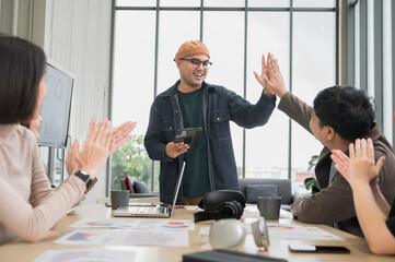 Asian male businessman Tag hands with friends, holding tablets, to brainstorm and talk about...