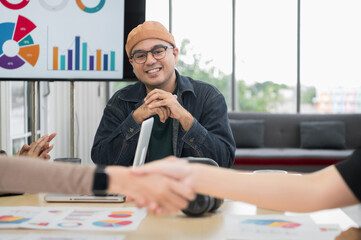 Asian male businessman Looking at friends holding hands After consulting, brainstorm and talk about analysis, innovation, collaboration. Online business, sales techniques, modern strategic planning