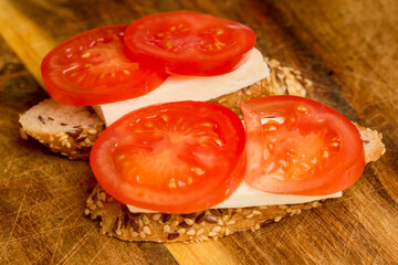 tomato slices and mozzarella cheese on a slice of seeded bread