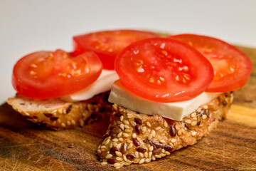 tomato slices and mozzarella cheese on a slice of seeded bread
