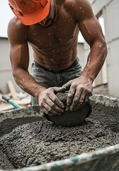 Construction worker mixing concrete in a wheelbarrow