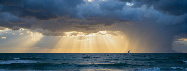 Dramatic sea view with sunlight breaking clouds, moment of hope