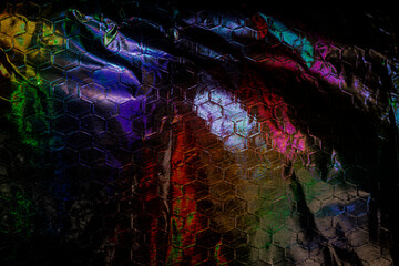 Aluminum foil laid over steel mesh, illuminated by polarizing light
