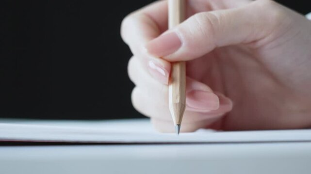 鉛筆を持つ手元と白紙