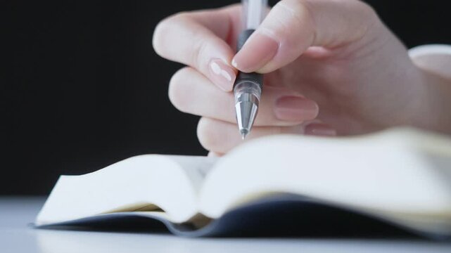 テキストとペンで勉強する人の手元