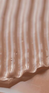 Vertical video of liquid make up foundation or concealer cosmetic texture close up. Beauty abstract