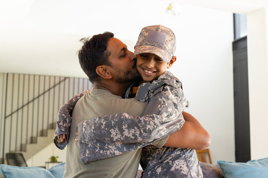 indian father hugging young son in military uniform, showing love and support