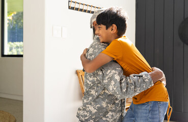 Young Indian boy hugging indian father in military uniform, showing love and happiness, copy space