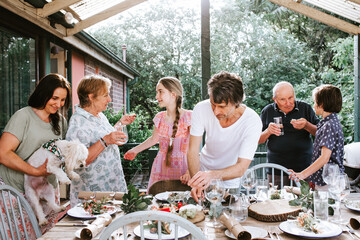 Happy family gathered around the dinner table on back patio