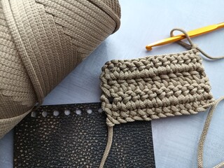 The process of crocheting a handbag made of cord and leather accessories. High quality photo